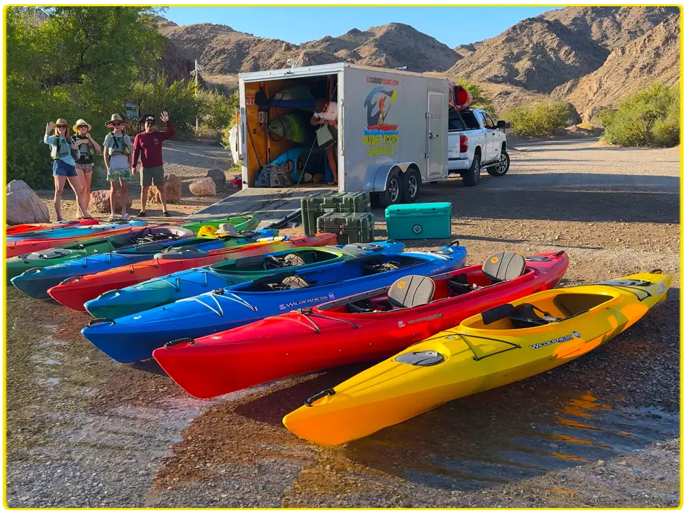 Colorful premium kayaks lined up at Willow Beach, ready for guided and self-guided kayak tours on the Colorado River, offering scenic paddling to Emerald Cove, Hoover Dam, and Black Canyon, perfect for outdoor adventures and kayaking enthusiasts.