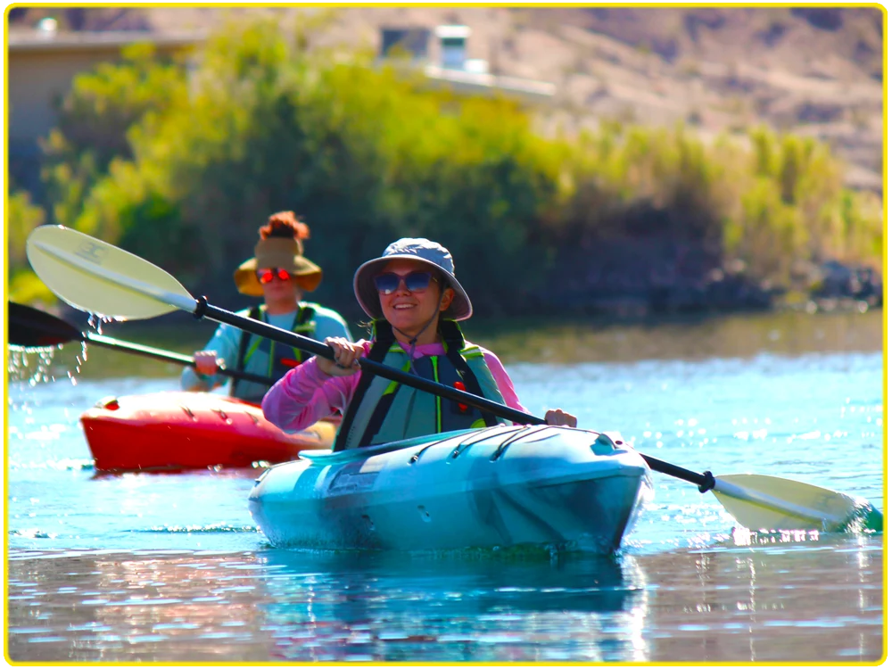 Solo paddler in a blue kayak on the calm, serene waters of the Colorado River, surrounded by peaceful desert landscapes, perfect for solo kayaking tours, nature exploration, adventure paddling, and desert kayaking experiences.