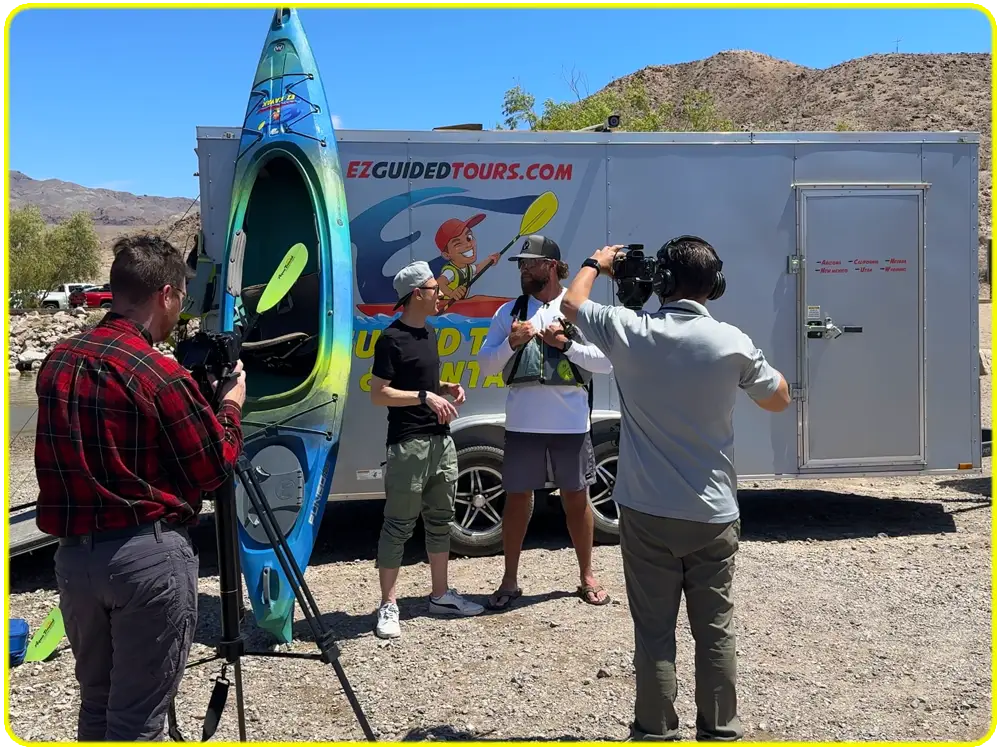 EZ Kayak team and media crew discussing guided kayak safety and tours at Willow Beach trailer site