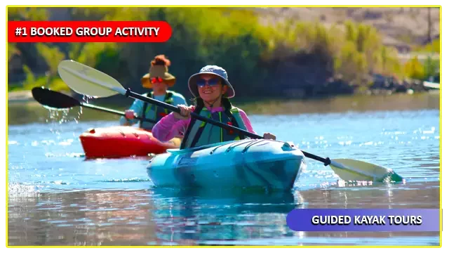 Smiling kayaker leading a group during a guided tour on the Colorado River, exploring scenic waters near Emerald Cove and Willow Beach.